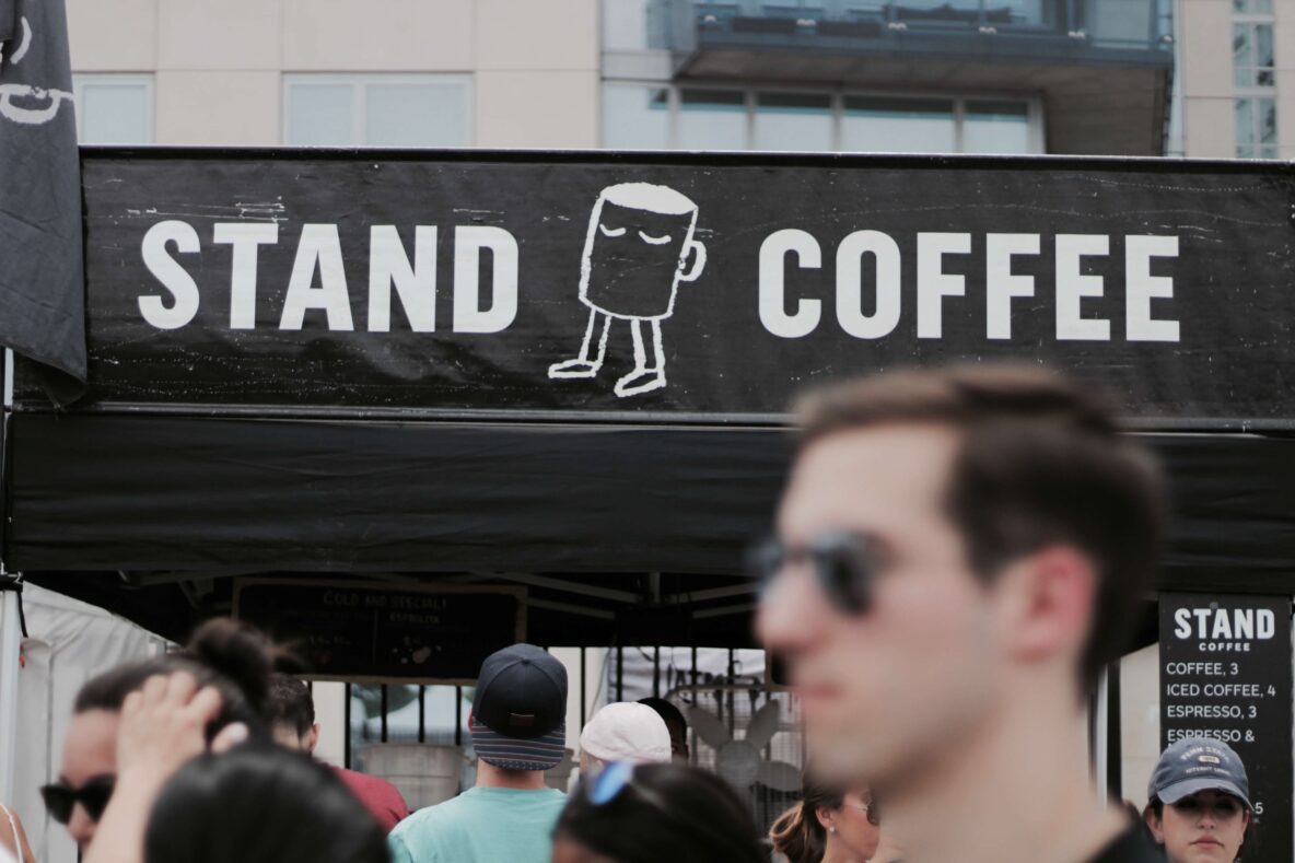 People in front of a coffee stand at an event.