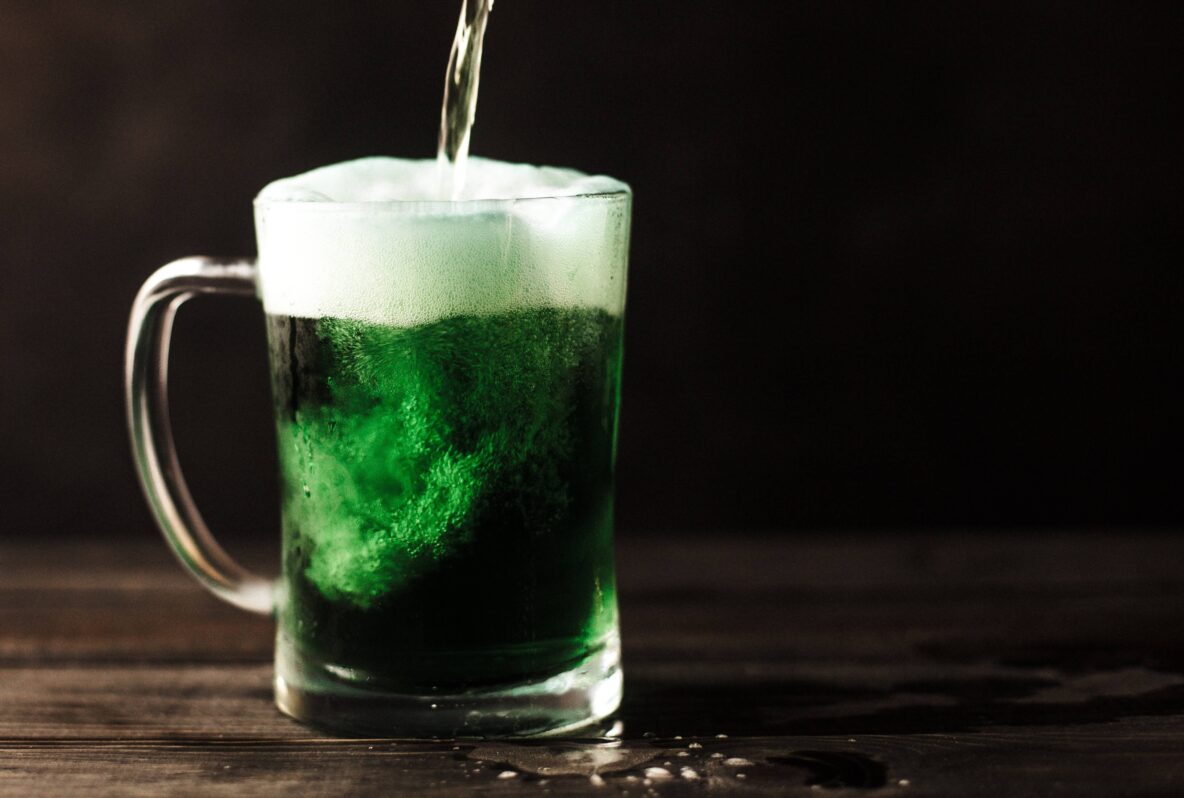 A pint of green beer being poured.