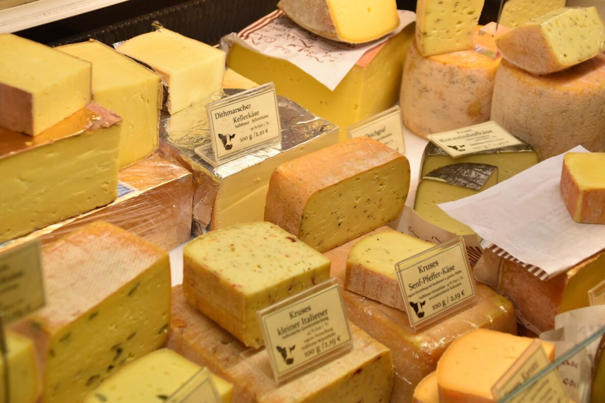 A variety of cheese in a refrigerated showcase