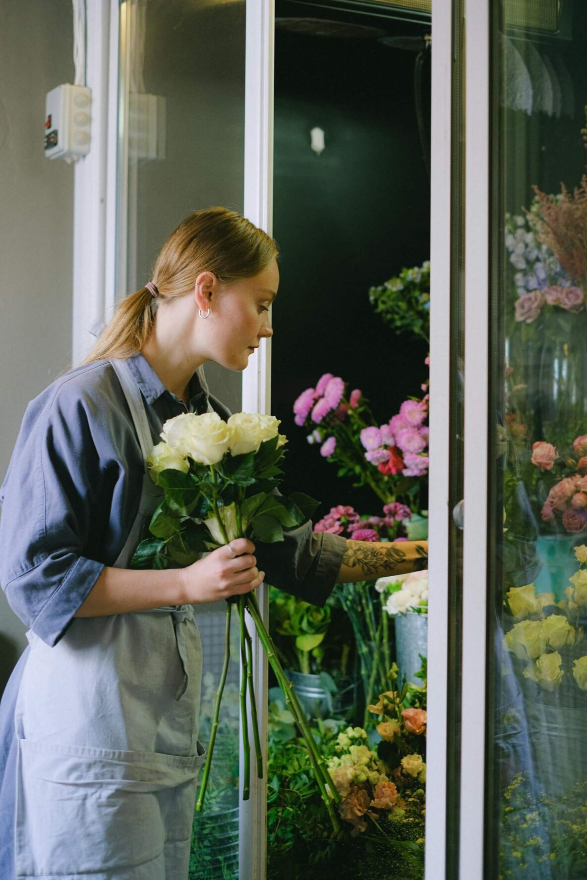 Women putting flowers into a refrigeration unit.